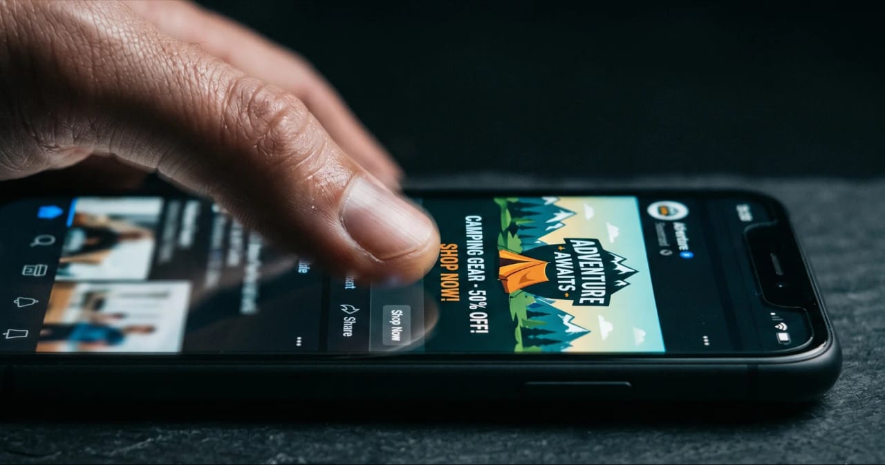 Facebook/Instagram offen auf einem Smartphone während gescrollt wird.